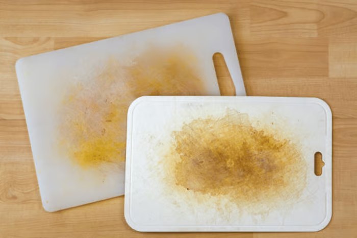 Planches à découper en plastique usées : surface entaillée et jaunie par des années de découpe