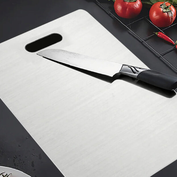 Couteau de chef posé sur la planche Katori en titane