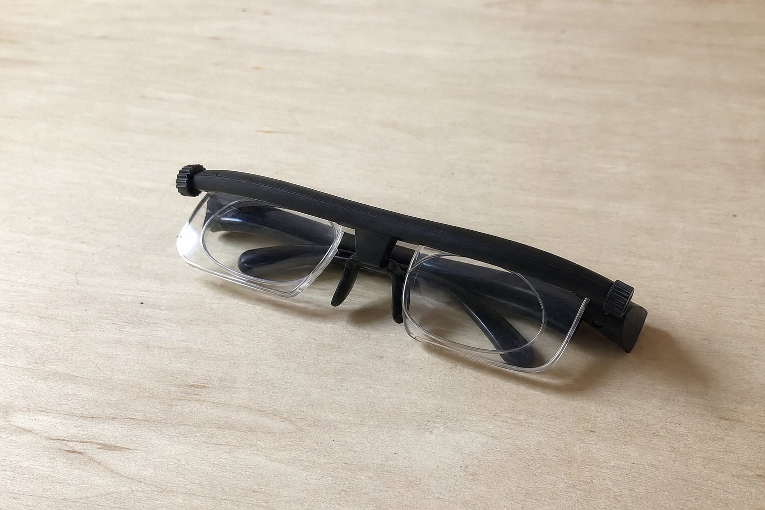 Les lunettes pliées sur une surface claire, molette de réglage visible
